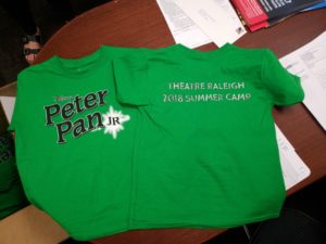 The T-shirts are green with the Disney Peter Pan Jr. on front. Theatre Raleigh 2018 summer camp is printed on the back