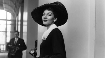Young woman in a large black hat and wearing a small smile