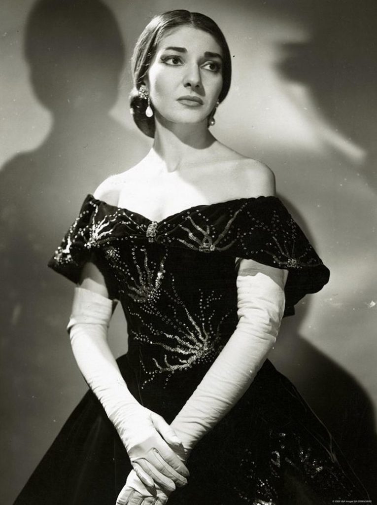 Young woman dressed in a ballgown and white gloves. Black and white