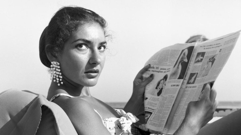 Young woman in a bathing suit reading a newspaper